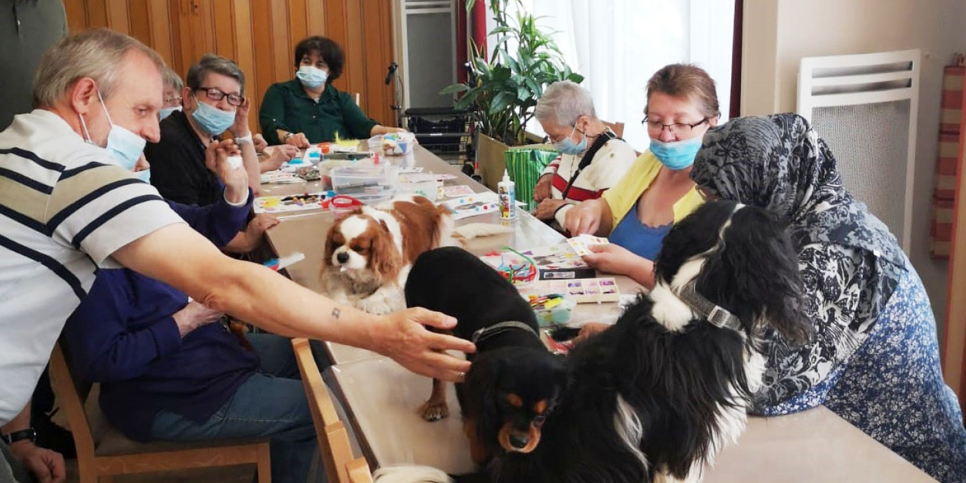 photo de l'atelier avec nos résidents et sur la table d'activités, les 3 cavaliers king charles
