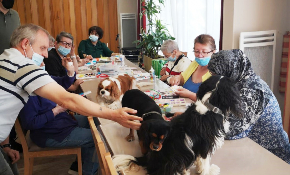 photo de l'atelier avec nos résidents et sur la table d'activités, les 3 cavaliers king charles