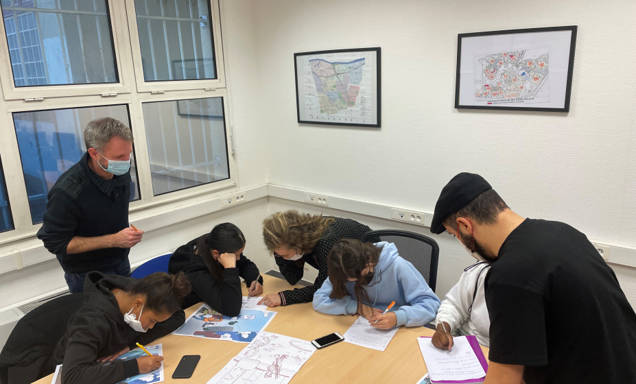 Des jeunes-filles encadrées par le graphiste de Hauts-de-Seine Habitat et les éducateurs de l'association 4 chemins travaillent sur un document de sensibilisation à l'environnement