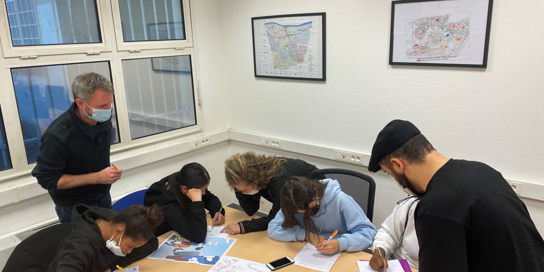 Des jeunes-filles encadrées par le graphiste de Hauts-de-Seine Habitat et les éducateurs de l'association 4 chemins travaillent sur un document de sensibilisation à l'environnement